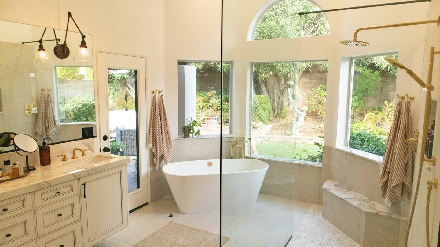 Modern bathroom with marble vanity and freestanding bathtub.